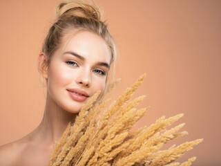 Wall Mural - Portrait of young smiling woman with a healthy  skin of a face. Happy girl with a spring field flowers