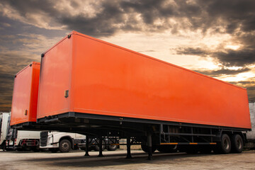 Red cargo trailer truck parking at sunset sky. Freight transportation.