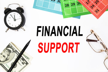 FINANCIAL SUPPORT. Abstract calendar, glasses, marker clock on the desktop. using as background business and finance concept.