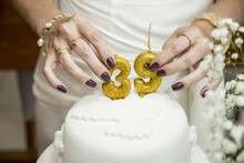 Closeup Shot Of A Woman Putting On The Number 39 Candles On A Cake