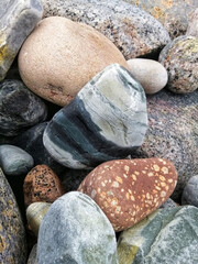 Sticker - Closeup vertical shot of a pile of colorful pebble stones on a Molen beach in Norway