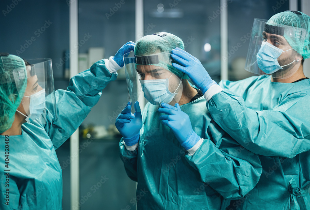 Doctors wearing ppe equipment face surgical mask and visor fighting against corona virus outbreak - Health care and medical workers concept - obrazy, fototapety, plakaty 