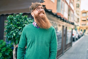 Wall Mural - Young irish man with redhead beard smiling happy walking at the city.