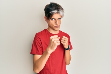 Sticker - Young hispanic man wearing casual clothes ready to fight with fist defense gesture, angry and upset face, afraid of problem