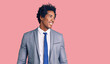 Handsome african american man with afro hair wearing business jacket looking away to side with smile on face, natural expression. laughing confident.