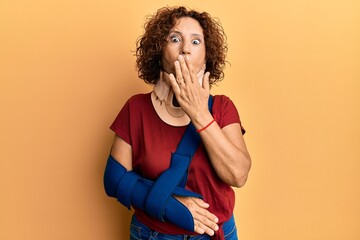 Sticker - Beautiful middle age mature woman wearing cervical collar and arm on sling covering mouth with hand, shocked and afraid for mistake. surprised expression