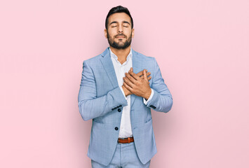 Sticker - Young hispanic man wearing business jacket smiling with hands on chest with closed eyes and grateful gesture on face. health concept.