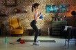 © nyul - Fitness training at home. Young woman doing leg workout, exercising in living room. Stay at home and stay fit and healthy.