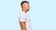 Handsome muscle man wearing casual white tshirt looking to side, relax profile pose with natural face and confident smile.