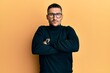 © Krakenimages.com - Handsome man with tattoos wearing turtleneck sweater and glasses skeptic and nervous, disapproving expression on face with crossed arms. negative person.