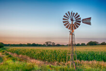 Vintage Windmill At Sunset With Cornfield.