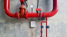Red Water Or Gas Pipeline With Gate Pressure Valve And Stainless Steel Test Box Installed On Concrete Wall With Copy Space. Line Pipe Industrial And Extinguisher Pump. 
