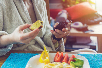 Wall Mural - Modern diabetes treatment, woman checking glucose level and dosing insulin with insulin pump before her healthy breakfast