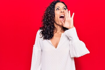 Canvas Print - Middle age beautiful woman wearing casual shirt shouting and screaming loud to side with hand on mouth. communication concept.