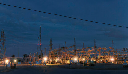 Ottawa Hydro Hawthorne Road Transformer Station at night with steel towers and high voltage lines and equipment nobody