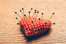 Close-up Of Straight Pin On Cushion At Table