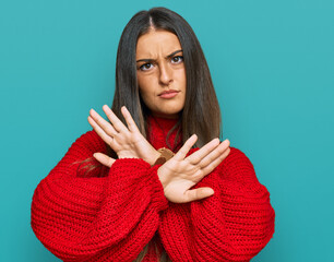 Beautiful hispanic woman wearing casual clothes rejection expression crossing arms doing negative sign, angry face