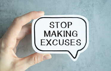 Closeup on businessman holding a card with text STOP MAKING EXCUSES, business concept image with soft focus background and vintage tone