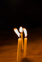 Three Yellow Candles Burning In The Dark. Copy Space