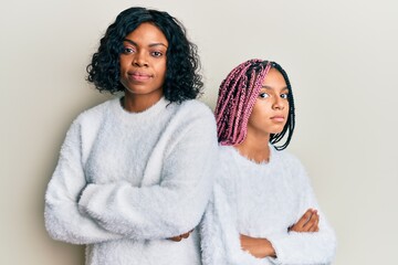 Poster - Beautiful african american mother and daughter with arms crossed gesture relaxed with serious expression on face. simple and natural looking at the camera.