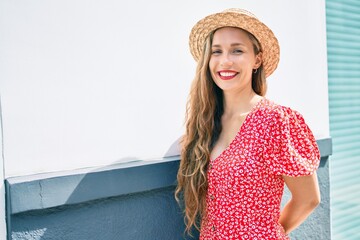 Sticker - Young blonde woman on vacation smiling happy leaning on the wall at street of city