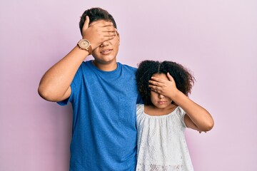 Poster - Young hispanic family of brother and sister wearing casual clothes together covering eyes with hand, looking serious and sad. sightless, hiding and rejection concept