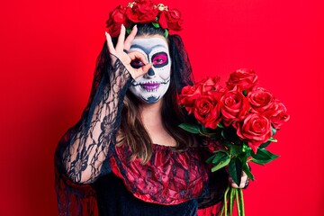 Poster - Young woman wearing day of the dead costume holding flowers smiling happy doing ok sign with hand on eye looking through fingers