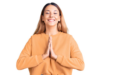 Beautiful young woman wearing casual clothes praying with hands together asking for forgiveness smiling confident.