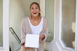 © MrsLePew - woman receiving package box from postman in front of house and happy surprised