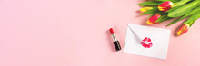 White Envelope With Red Lipstick Kiss And Bouquet Of Tulips On Pink Pastel Background. Valentine's Day Decoration Concept. Banner For Website.