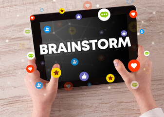 Close-up of a touchscreen with BRAINSTORM inscription, social networking concept