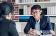 © weedezign - young asian businessman and businesswoman talking about business agreement at meeting table in modern office.business partnership concept.satisfied the deal with client negotiation