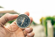 © TECHNOLOGY FACTORY - Man hand holding compass on city and car blurred background Using wallpaper or background travel or navigator image.