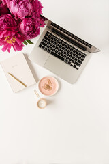Wall Mural - Home office desk workspace with laptop, pink peony flowers bouquet and notebook on white background. Flat lay, top view freelance work concept.