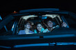 © Svitlana - Portrait of three young friends looking emotional, laughing while sitting together in the car and watching a movie in a drive in cinema
