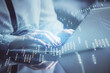 © peshkova - Double exposure of businesswoman hands typing on computer and financial graph hologram drawing. Stock market analysis concept.