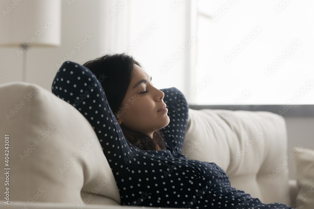 Side view relaxed young asian korean woman daydreaming napping leaning on comfortable couch, enjoying peaceful stress free lazy leisure weekend time in living room, meditating with close eyes. - obrazy, fototapety, plakaty 