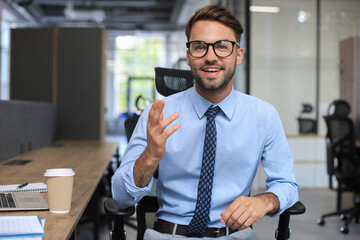 Confident businessman looking at camera talking about company strategy and business plan, explaining corporate success.