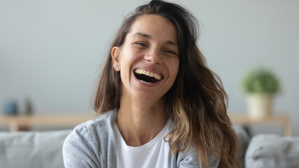 Sticker - Close up overjoyed woman laughing, sitting on couch at home, head shot portrait young female chatting online with friends or relatives, looking at camera, having fun, making call or shooting video