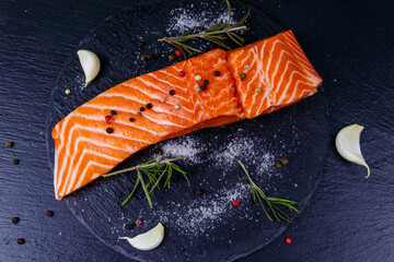 Sticker - Raw salmon fillet with spices on black slate. Top view