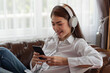 © surachetkhamsuk - Young Asian woman enjoy listening to music with headphones, happy and relaxing time