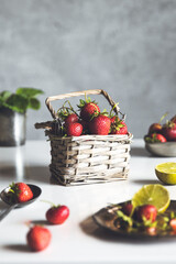 Wall Mural - fresh strawberries in a basket on a white wooden table