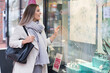 © MrsLePew - Happy woman is shopping with bag enjoying in shopping on store window. Consumerism, shopping, lifestyle concept
