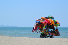 Characteristic, Colorful Cart Full Of Swimming Inflatable Toys And Beach Accesories. Toys Seller Cart With Plastic  Toys And Beach Balls On The Sandy Beach. 