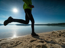 Dynamic Silhouette Of Athletic Man In Compression Tights. Man During Morning Workout At Sea Coast