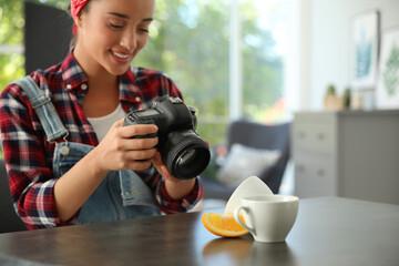 Poster - Young photographer taking picture of cups at table indoors, closeup