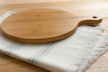 Empty wooden board and napkin on table, closeup