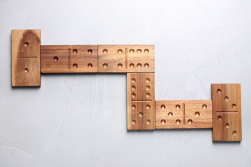 Poster - Wooden domino tiles on light grey table, flat lay