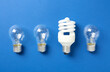 © New Africa - Vintage and modern lightbulbs on blue background, flat lay