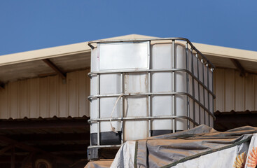 Wall Mural - white ibc container in outdoor stock yard of factory, white plastic chemical tank.